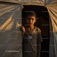 Boy Standing in Camp Tent Bathed in Golden Sunset Light
