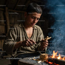 Young Artisan Carving Wood Beside a Fire