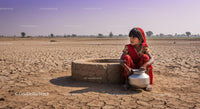 Young Girl by Well on Barren Land in Traditional Red Attire