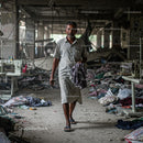 Man Walking Through Abandoned Textile Factory
