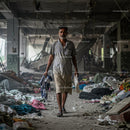 Man Walking Through Abandoned Building with Debris
