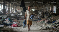 Man Walking Through Rubble in a Derelict Building