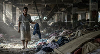 Man Walking Through Debris in Abandoned Building