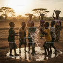 Joyful Children Playing at Water Pump in African Village