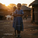 Sisters Standing in an African Village at Sunset