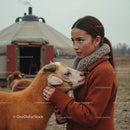 Woman Embracing a Goat Near a Yurt in Autumn Landscape