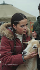 Young Woman in Winter Coat Petting a Goat
