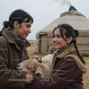 Women Sharing a Moment with a Sheep in Front of Yurt