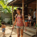 Young Girl Sweeping in Tropical Home Garden