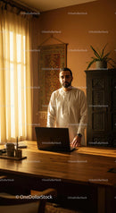 Professional Man in Ethnic Attire with Laptop in Sunlit Room