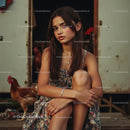 Young Woman in Floral Dress Sitting Near Brown Hen