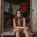 Young Woman in Colorful Dress Sitting in Rustic Doorway