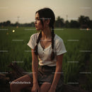 Contemplative Young Woman Sitting in Lush Green Field