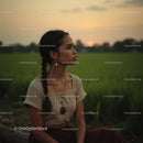 Pensive Woman Sitting in a Tranquil Countryside at Sunset
