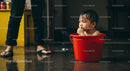 Cute Baby in Red Bucket Enjoying Playtime Indoor