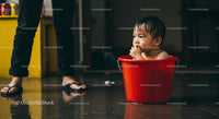 Cute Baby in Red Bucket Enjoying Playtime Indoor