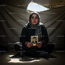 Somber Refugee Woman Holding Cherished Photograph