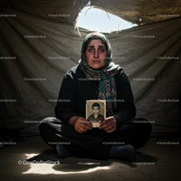Somber Refugee Woman Holding Cherished Photograph