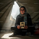 Woman Holding Photograph Inside Refugee Tent