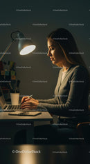 Woman Working Late at Night with Laptop and Desk Lamp