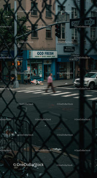 City Street with Chain Link Fence and Pedestrian