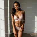 Smiling Woman in Sunlit Room Wearing Elegant Lingerie