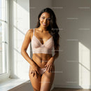 Smiling Woman in Elegant Pink Lingerie in Sunlit Room