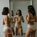 Laughing Woman in Beige Lingerie Admiring Mirror Reflection