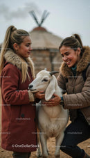 Two Young Women Bonding with Goat in Rustic Setting