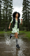 Woman Running on Forest Path Splashing Through Puddle