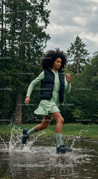 Woman Running Through Water in Green Forest Setting