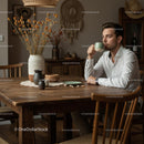 Man Enjoying Coffee at Rustic Wooden Table in Cozy Interior