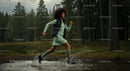 Woman Running Through Forest Stream in Green Dress