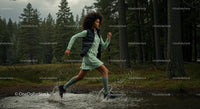 Woman Running Through Forest Stream in Green Dress