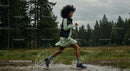 Woman Running Through Forest Puddle in Energetic Outdoor Scene
