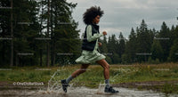 Woman Running Through Forest Puddle in Energetic Outdoor Scene