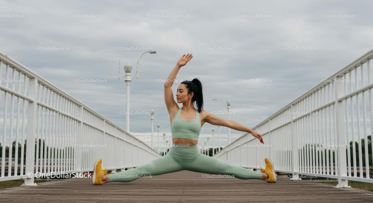Woman Performing Yoga Split on Outdoor Bridge