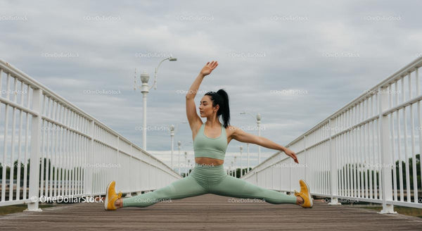 Woman Performing Yoga Split on Outdoor Bridge