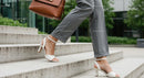 Businesswoman in Gray Trousers and White Heels Ascending Steps