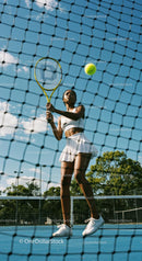 Female Tennis Player in Action at Sunny Outdoor Court