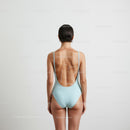 Elegant Woman in Minimalist Swimsuit with Back Tattoo