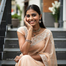 Smiling Woman in Elegant Beige Saree with Jewelry