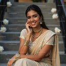 Smiling Woman in Elegant Beige Sari with Gold Jewelry