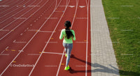 Woman Jogging on Outdoor Running Track in Neon Athletic Wear