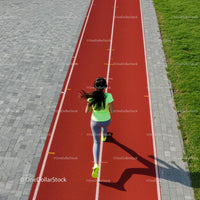 Woman Jogging on a Red Running Track in Sunny Weather