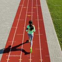 Woman Running on Red Athletic Track in Green Sportswear