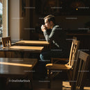Man Enjoying Coffee in Sunlit Cafe