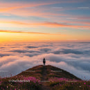 Silhouette of a Lone Traveler Above a Sea of Clouds at Sunrise