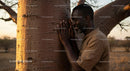 Man Embracing a Baobab Tree at Sunset