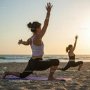 Women Practicing Yoga on the Beach at Sunset